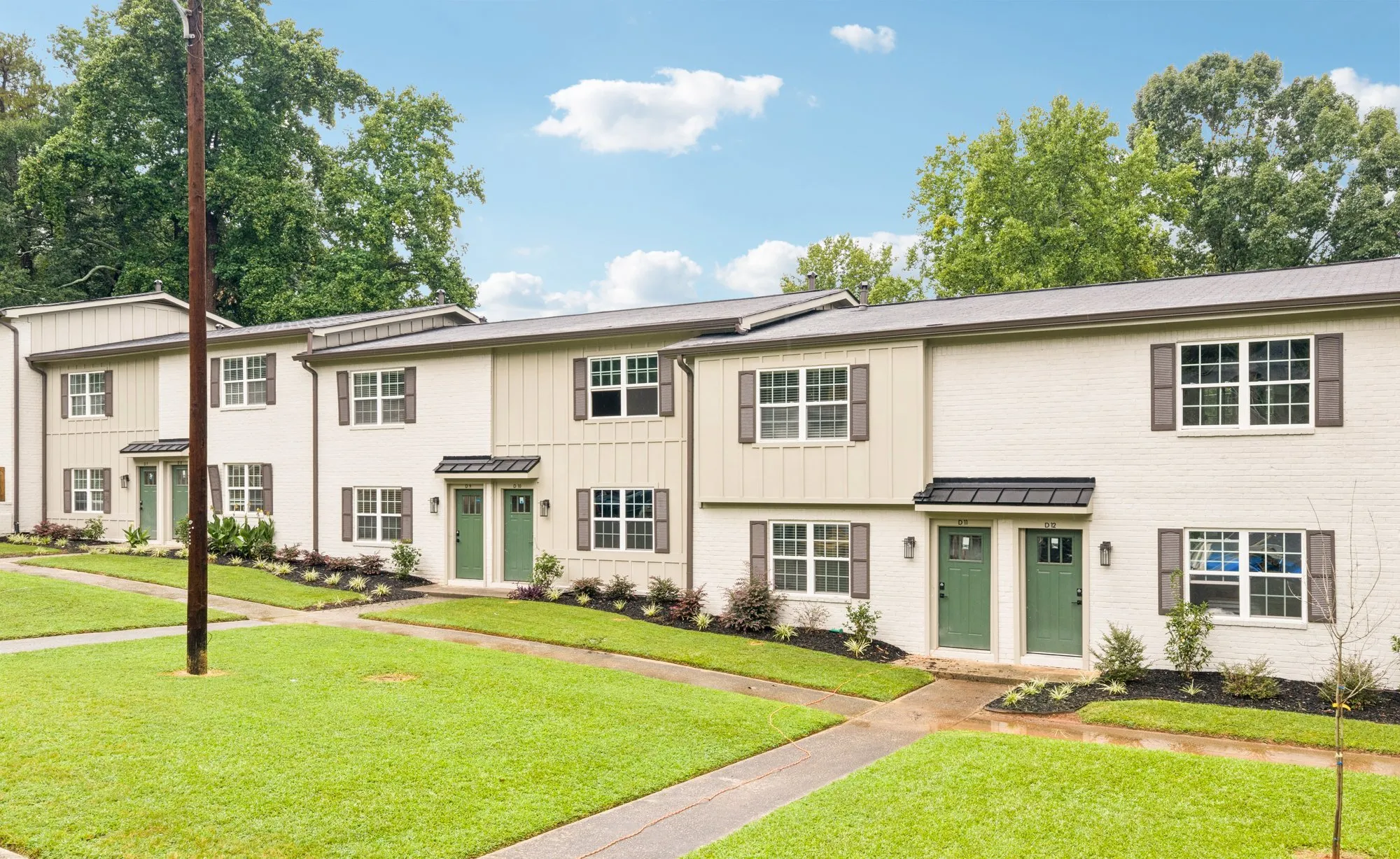 Row of townhomes along a grassy walkway.