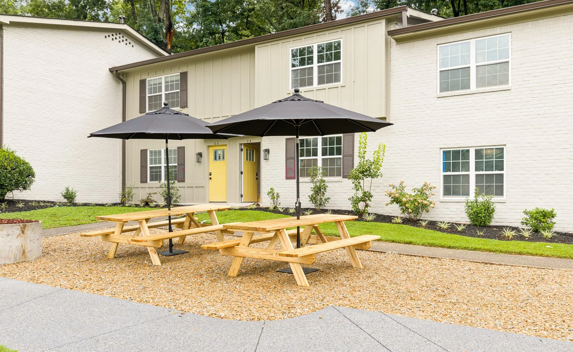 Courtyard picnic tables under umbrellas by the townhomes.